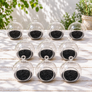 close-up view of three mini flat-bottom hanging glass terrariums with white sand and dark sand varieties, showing the hanging loop and clear glass construction, styled on a wooden shelf