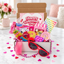 collection of small valentine's day gift boxes stacked together showing festive red and pink packaging with heart designs and colorful tissue paper peeking out from the top