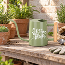 gray watering can let love bloom for sale, soft gray muted tone with romantic floral print, contemporary minimalist shape with functional spout, durable powder-coated metal with sealed seams, ideal for mixed container gardens and patio displays, excellent gift for modern home gardeners