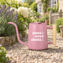 pink watering can peace love plants for sale, cheerful coral pink with motivational wellness-focused design, practical 1-liter size with precision spout technology, stylish accent piece for bright modern interiors, great for maintaining herb gardens and kitchen plant collections, lovely gift for eco-conscious homemakers